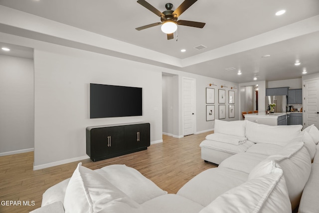 living room with light wood finished floors, visible vents, recessed lighting, and baseboards