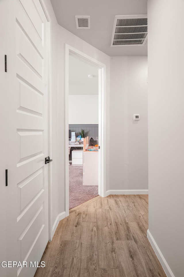 corridor with visible vents, baseboards, and wood finished floors