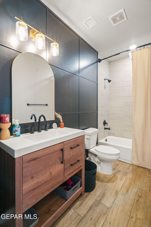 bathroom featuring visible vents, toilet, vanity, and wood finished floors