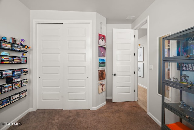 bedroom with a closet, carpet flooring, and baseboards