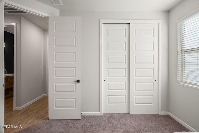 unfurnished bedroom featuring carpet flooring, baseboards, and a closet