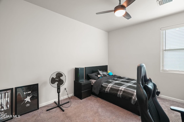 carpeted bedroom with visible vents, a ceiling fan, and baseboards