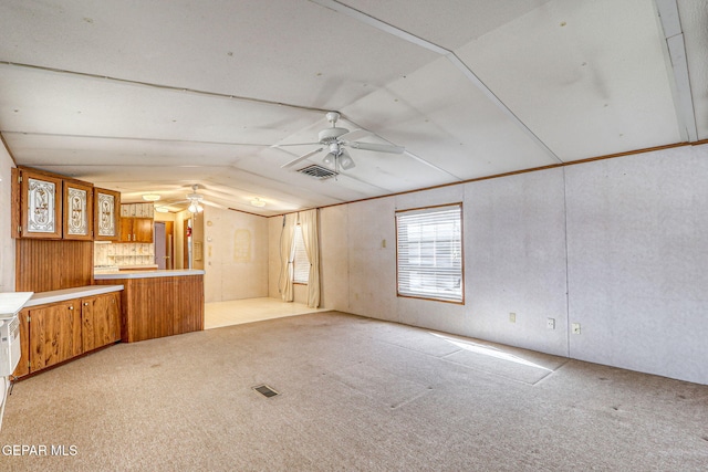 interior space with lofted ceiling, light colored carpet, visible vents, and ceiling fan