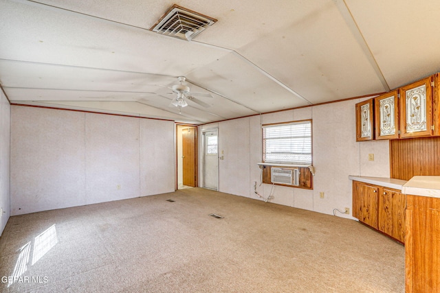 carpeted empty room with visible vents, cooling unit, ceiling fan, and vaulted ceiling