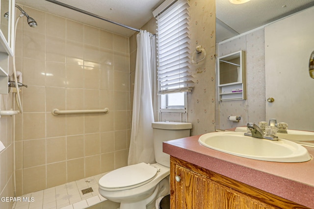 bathroom with vanity, toilet, and tiled shower