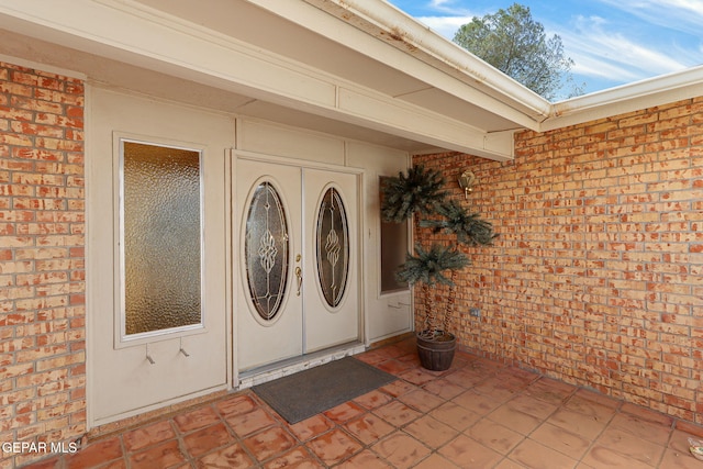 view of exterior entry with brick siding and washer and dryer