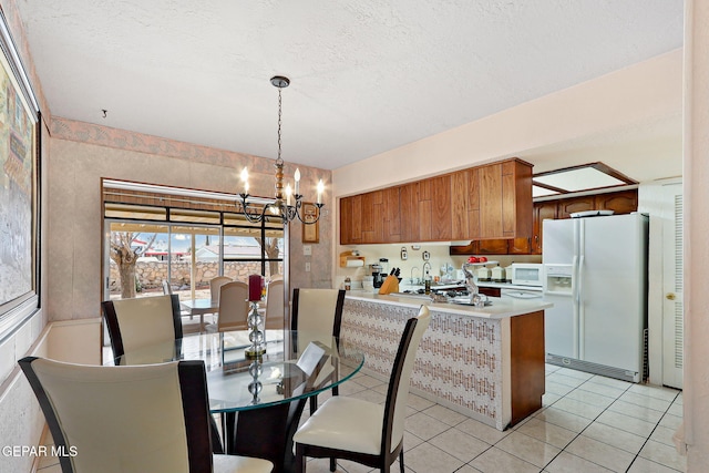 dining room featuring a textured ceiling, an inviting chandelier, and light tile patterned flooring