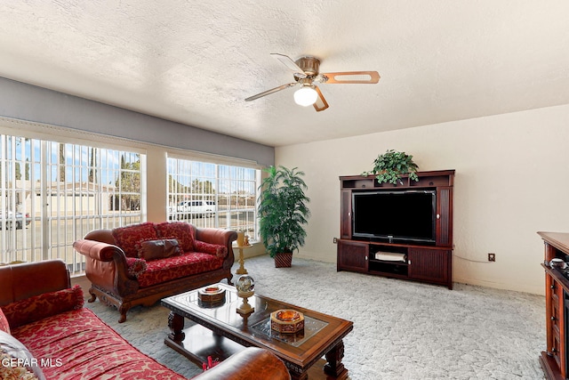 living area featuring a textured ceiling, carpet floors, and ceiling fan