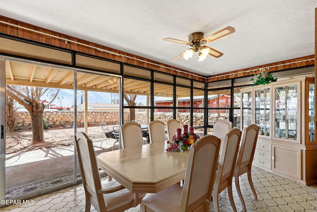 sunroom / solarium featuring a ceiling fan