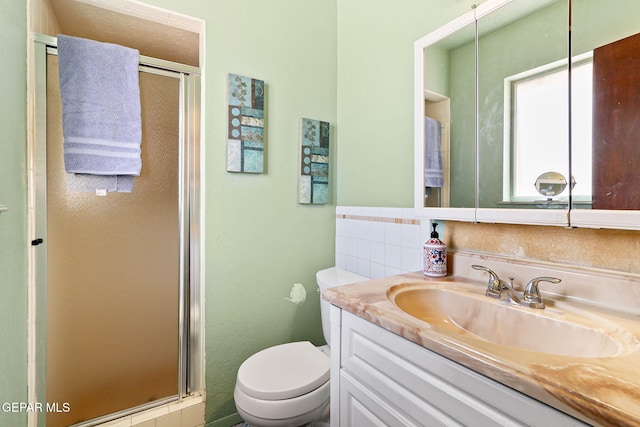 bathroom featuring toilet, a stall shower, and vanity