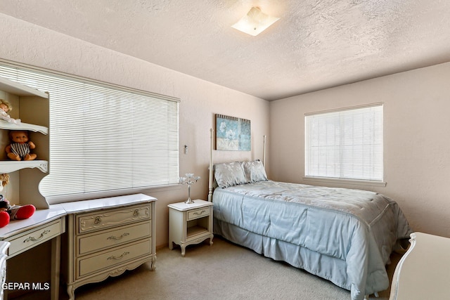 bedroom with a textured ceiling and light carpet