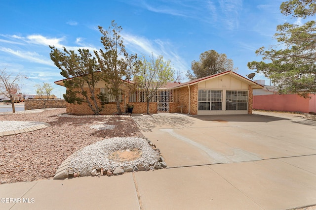 ranch-style home featuring brick siding, board and batten siding, and fence