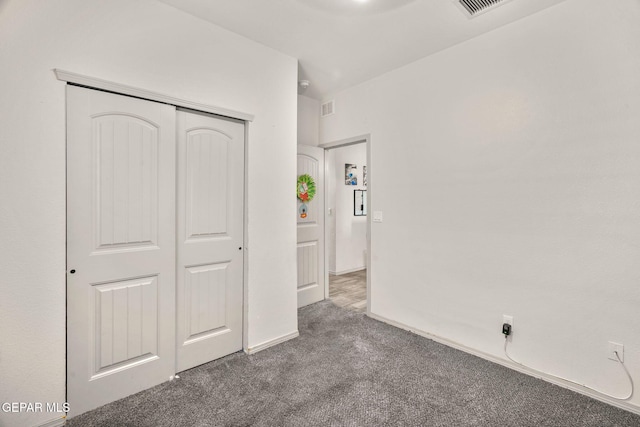 unfurnished bedroom featuring carpet flooring, baseboards, visible vents, and a closet