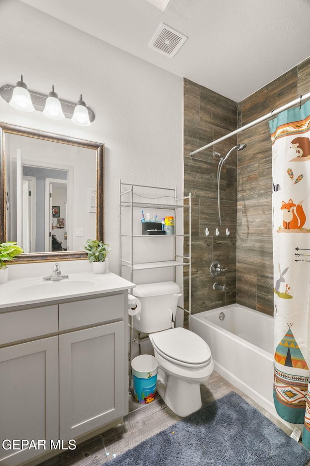 full bath featuring visible vents, toilet, vanity, and shower / tub combo with curtain