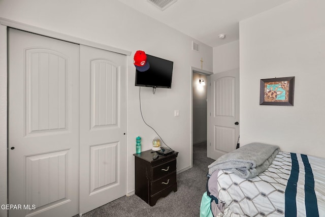 carpeted bedroom with visible vents and a closet