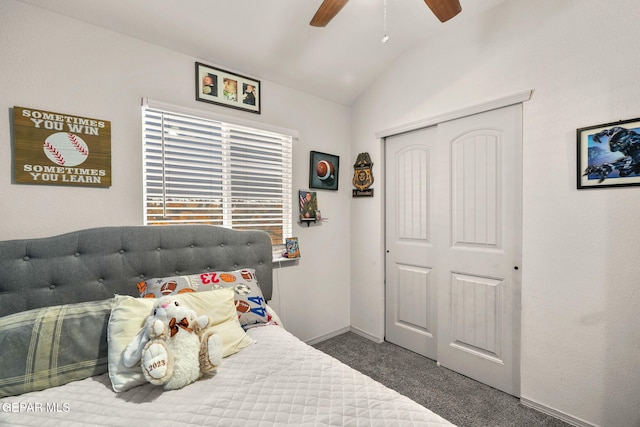 bedroom with baseboards, dark carpet, vaulted ceiling, a closet, and a ceiling fan