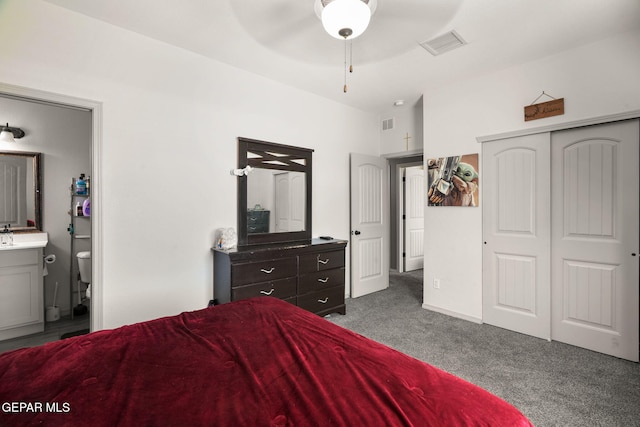 bedroom with carpet, visible vents, ensuite bath, a sink, and a closet