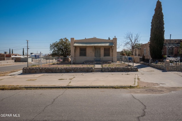 view of front of house featuring a tiled roof, a fenced front yard, and stucco siding