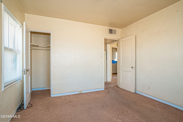 unfurnished bedroom with a closet, visible vents, baseboards, and carpet floors