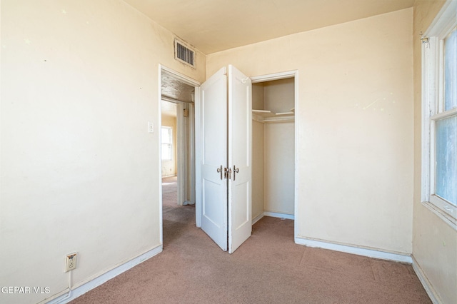 unfurnished bedroom with a closet, baseboards, visible vents, and carpet floors