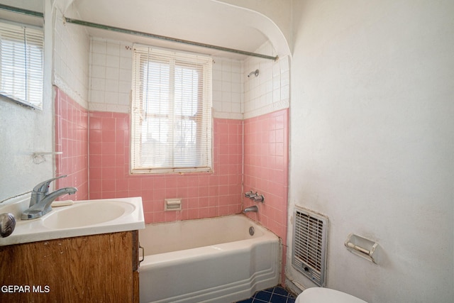 bathroom with heating unit, plenty of natural light, bathtub / shower combination, and vanity