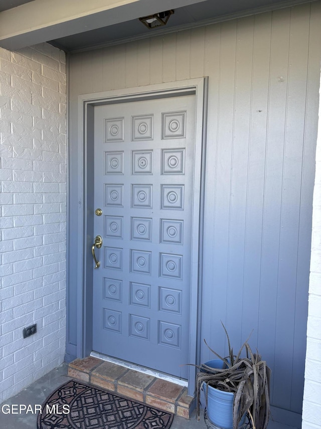 doorway to property with brick siding