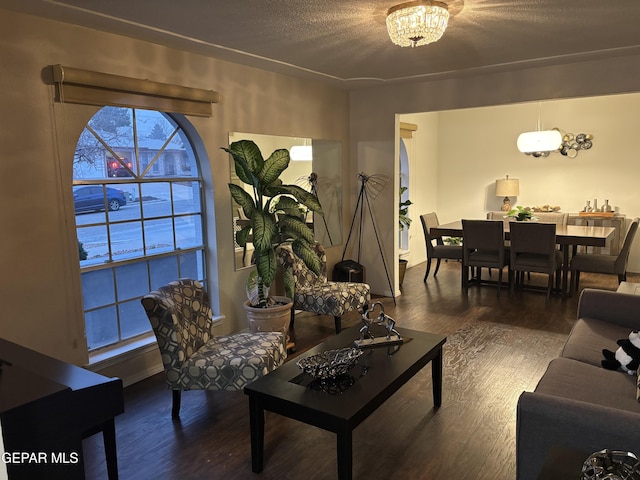 living area featuring an inviting chandelier, wood finished floors, and a textured ceiling