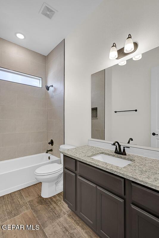 full bathroom featuring visible vents, vanity, toilet, and shower / bathtub combination