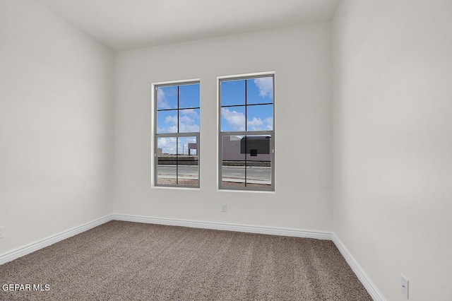 carpeted spare room with baseboards