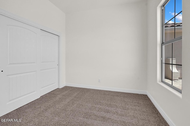 unfurnished bedroom with carpet, baseboards, and a closet