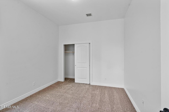 unfurnished bedroom featuring a closet, baseboards, and carpet floors