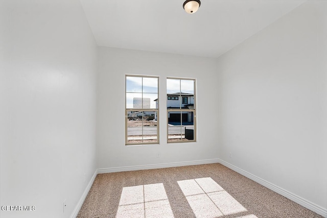 spare room featuring baseboards and carpet floors