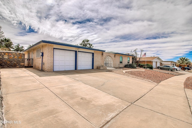 view of front of property featuring brick siding, driveway, and an attached garage