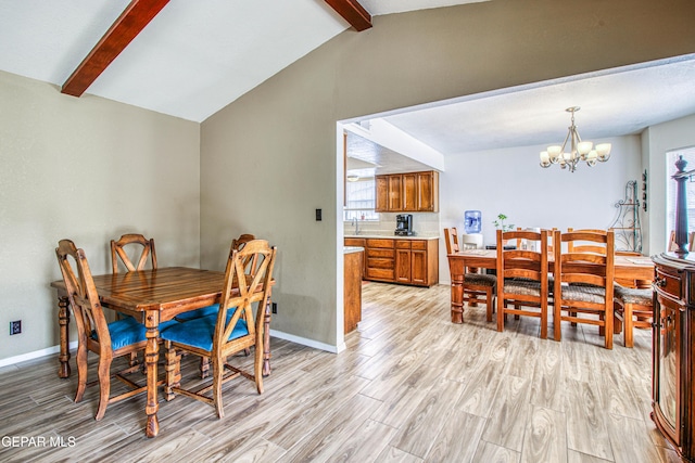 dining room featuring a chandelier, baseboards, lofted ceiling with beams, and light wood-style floors