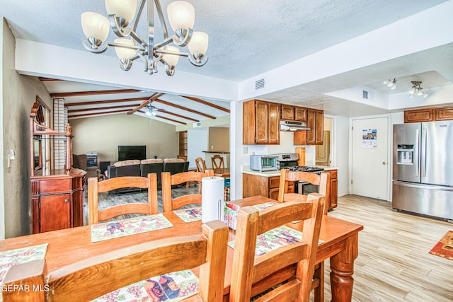 dining area with visible vents, a textured ceiling, vaulted ceiling with beams, and light wood finished floors