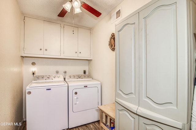 laundry area with washing machine and clothes dryer, visible vents, wood finished floors, a textured ceiling, and a ceiling fan