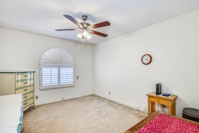 carpeted bedroom featuring a textured ceiling and a ceiling fan