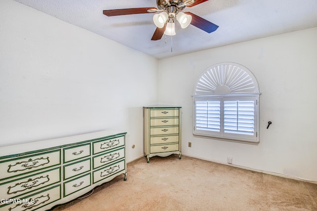 bedroom with light colored carpet, a textured ceiling, and ceiling fan