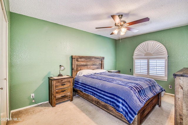 bedroom featuring carpet, baseboards, ceiling fan, a textured ceiling, and a textured wall