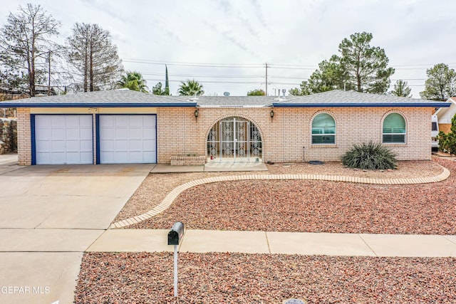 ranch-style house featuring brick siding, driveway, an attached garage, and a shingled roof