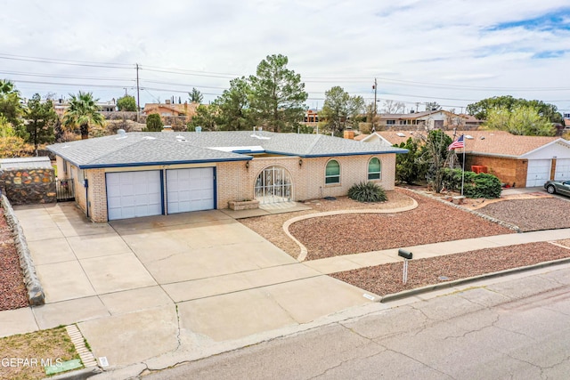 single story home featuring driveway, brick siding, roof with shingles, and an attached garage