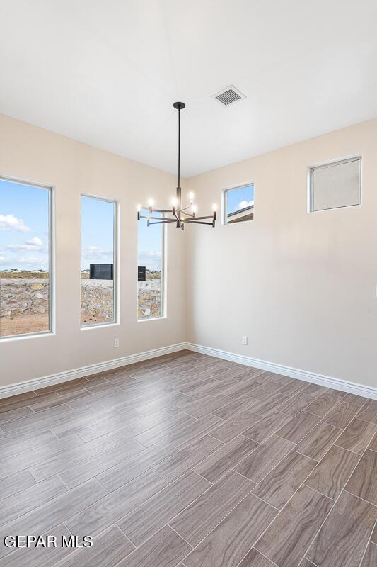 935 Bromyard Dr, Horizon City, TX 79928 - unfurnished room with baseboards, a healthy amount of sunlight, visible vents, and wood finish floors