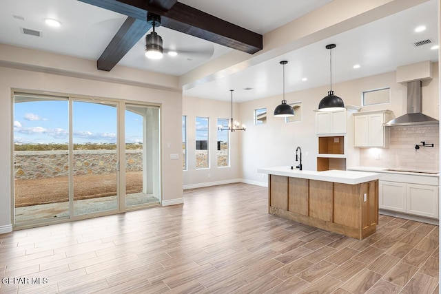 935 Bromyard Dr, Horizon City, TX 79928 - kitchen with visible vents, backsplash, wall chimney exhaust hood, and beamed ceiling
