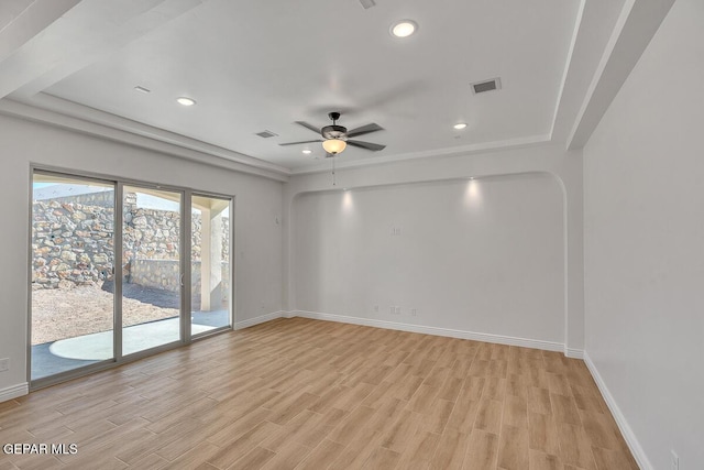 empty room with visible vents, baseboards, light wood-type flooring, recessed lighting, and arched walkways