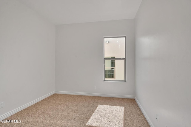 carpeted empty room with baseboards