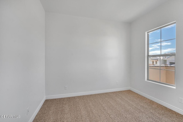 carpeted spare room with baseboards