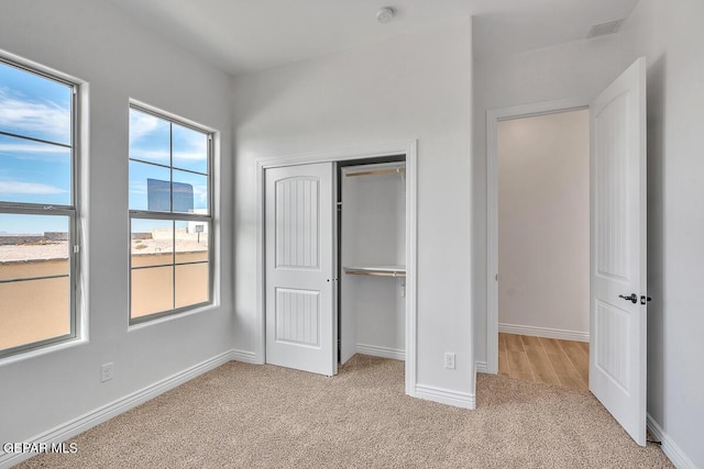 unfurnished bedroom featuring a closet, baseboards, visible vents, and carpet flooring