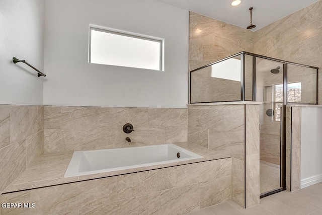 full bathroom with a shower stall, a bath, and tile patterned floors