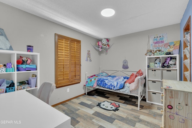 bedroom featuring baseboards and wood finished floors