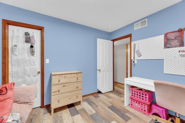 office area featuring wood finished floors, visible vents, and baseboards